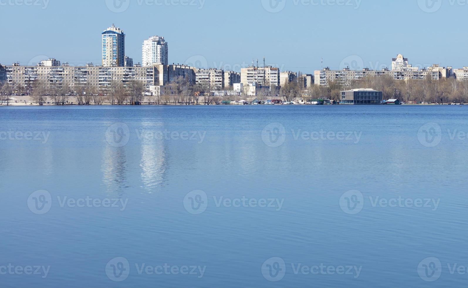 tiefes Blau des Frühlingshimmels spiegelt sich in der ruhigen Glätte des Flusses foto