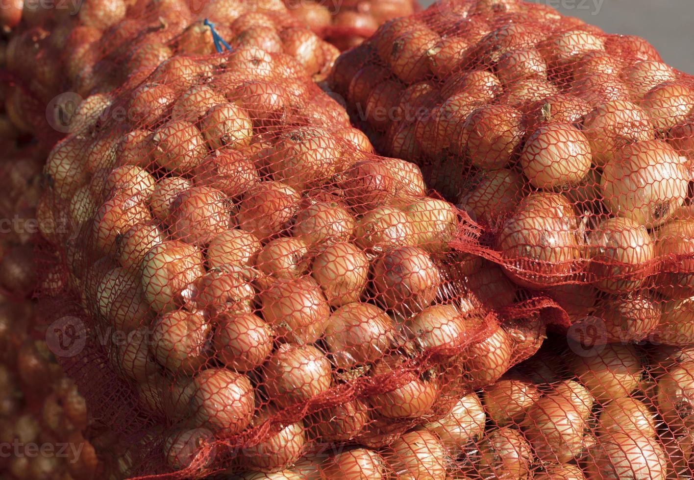 Zwiebeln in Tüten werden auf dem Markt verkauft foto