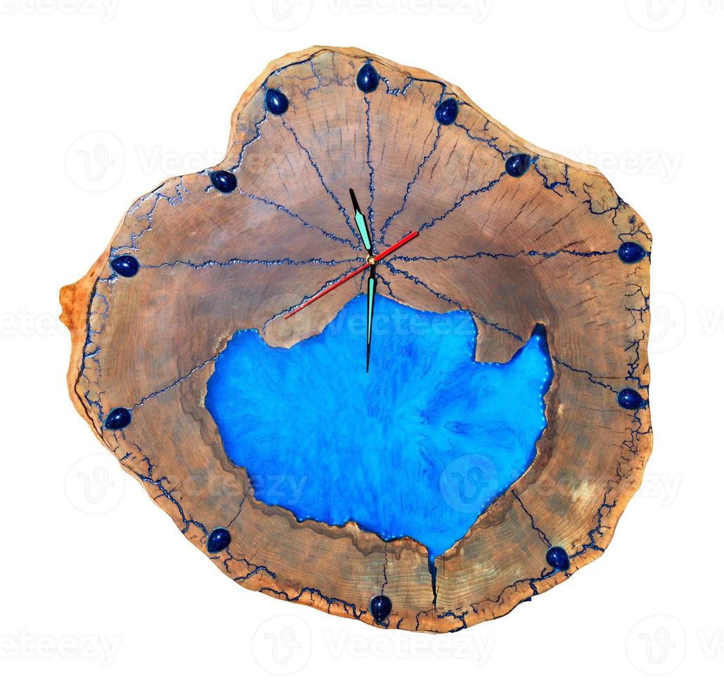 Schöne originale Holzwanduhr aus Baumwurzel und blauem Epoxid auf weißem Hintergrund. foto