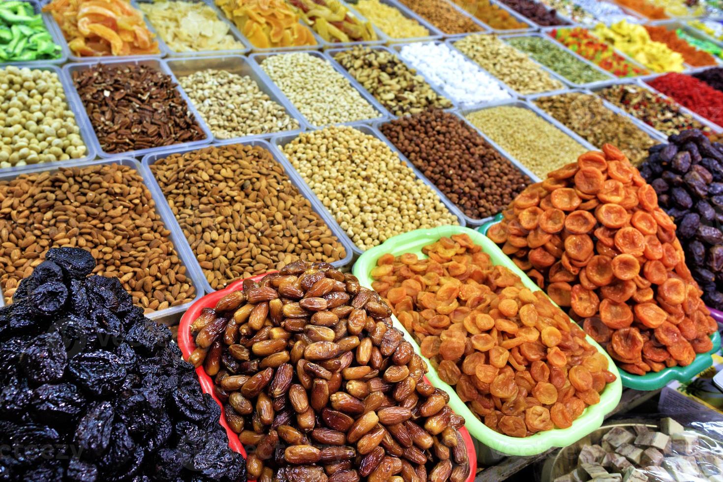 Datteln, getrocknete Aprikosen, Pflaumen vor dem Hintergrund verschiedener Nüsse, Mandeln, Haselnüsse, Walnüsse, Cashewnüsse in Unschärfe. foto