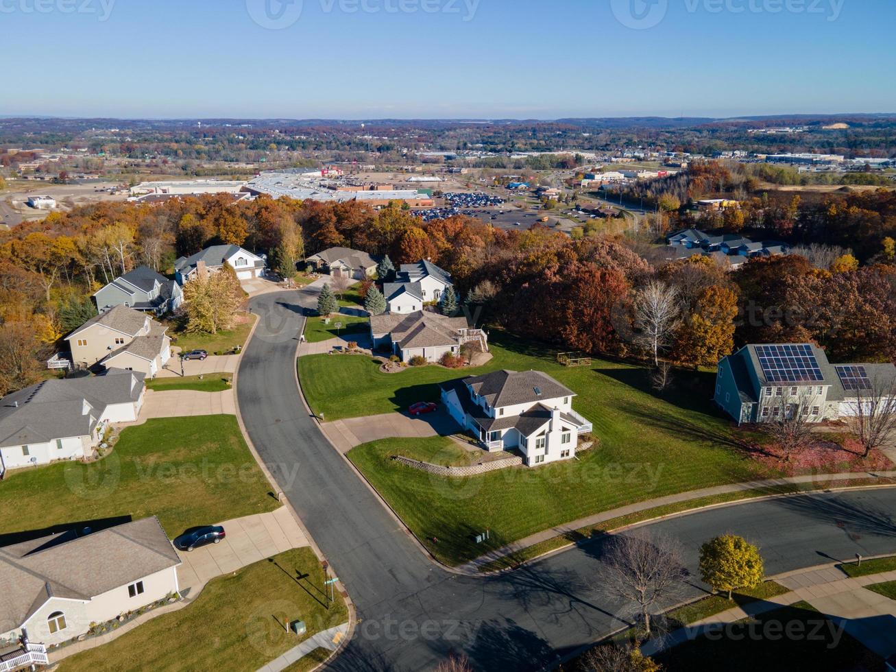 neuere wohngegend in eau claire, wisconsin. große Häuser mit großen grünen Höfen. leuchtende Herbstfarben in der umliegenden Landschaft. breite Straßen, Gehwege und Einfahrten. foto