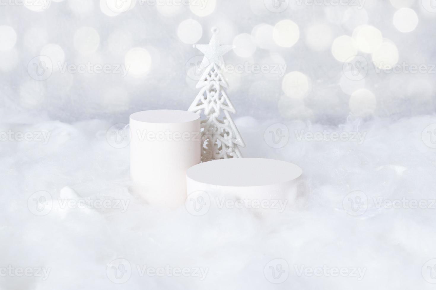 Podiums-Mok-up für Kosmetik im Schnee mit einem Weihnachtsbaum auf Bokeh-Hintergrund foto