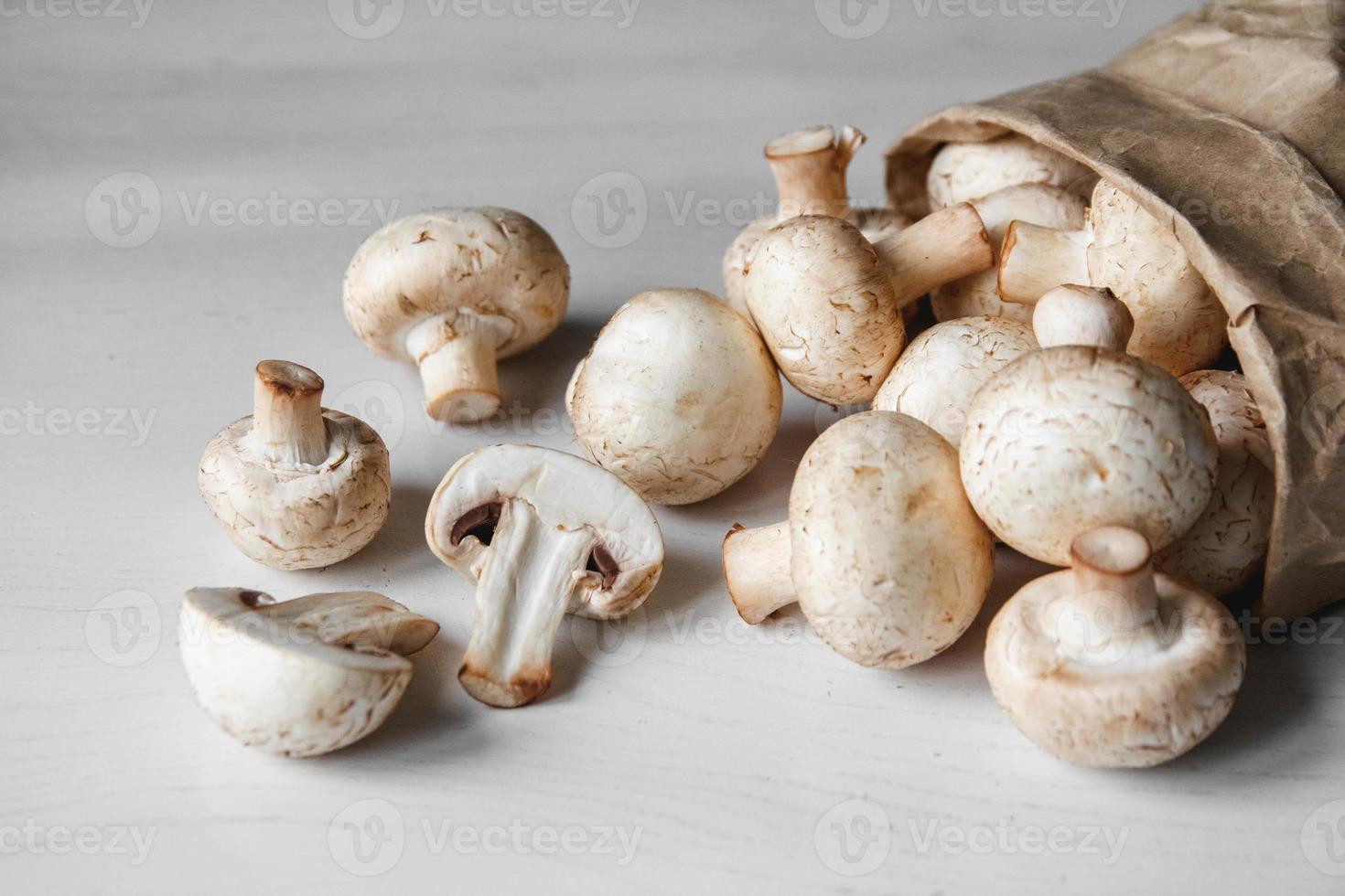 Champignons Champignons in Papiertüte auf einem weißen Holztisch foto