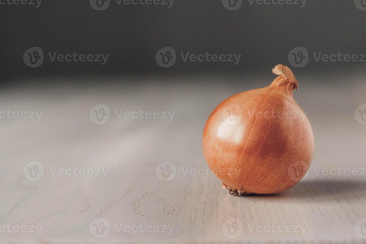 Zwiebeln auf weißem Holztisch auf grauem Hintergrund foto