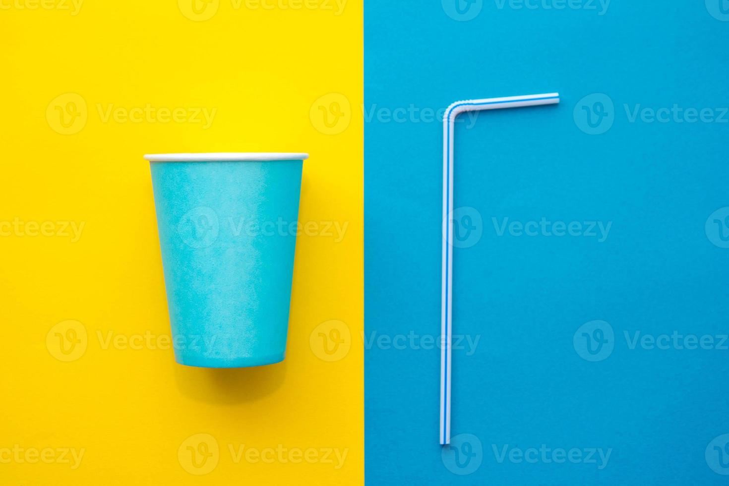 blaue Pappbecher mit trinkenden farbigen Plastikstrohhalmen gelber und blauer Hintergrund foto