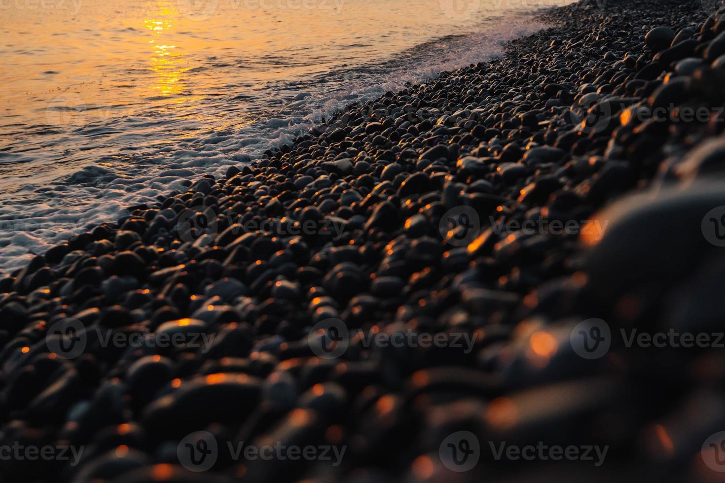 kleine Steine am Meer mit Bokeh-Effekt foto