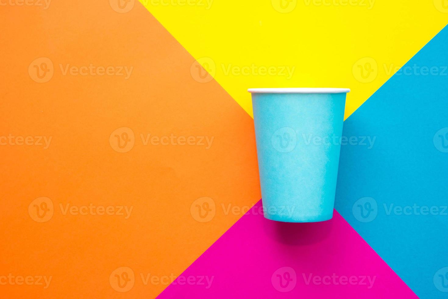 Einwegbecher aus blauem Papier auf schönem mehrfarbigem Hintergrund foto