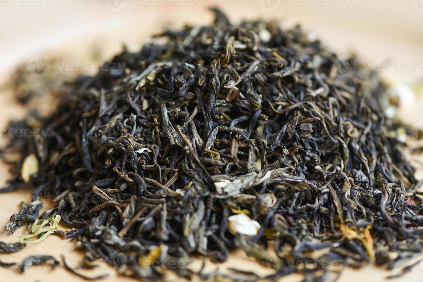 chinesischer trockener Tee auf Holzhintergrund, Jasmintee getrocknet für Brühtee, Blattschwarztee foto