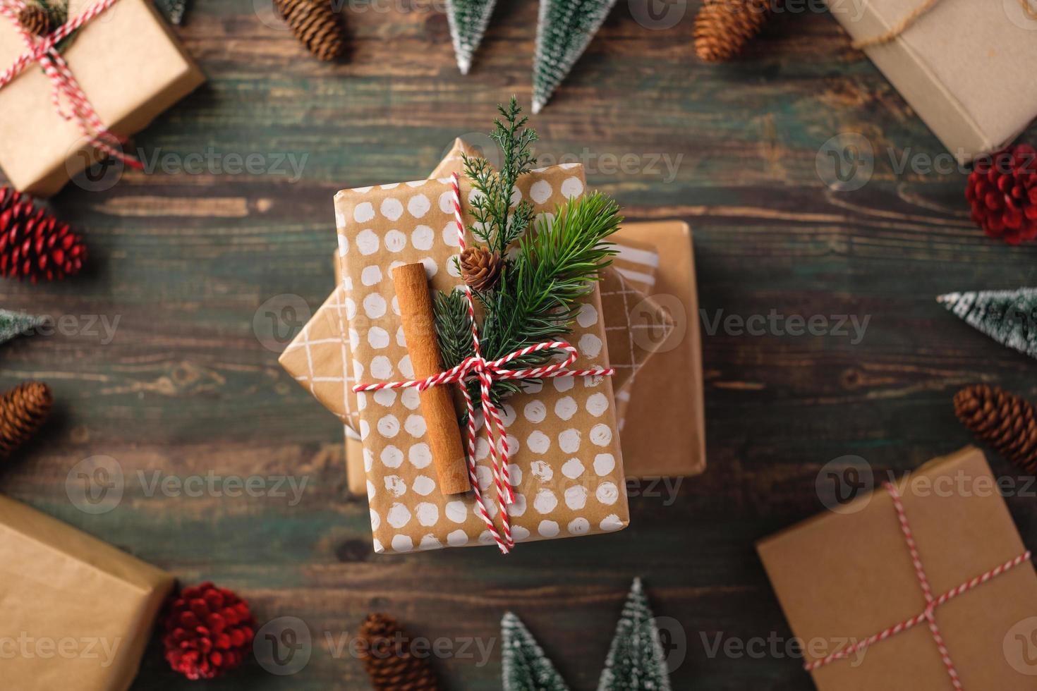 handgemachte Weihnachtsgeschenkbox mit braunem Papierdekor mit Tannenholz auf Holztisch foto