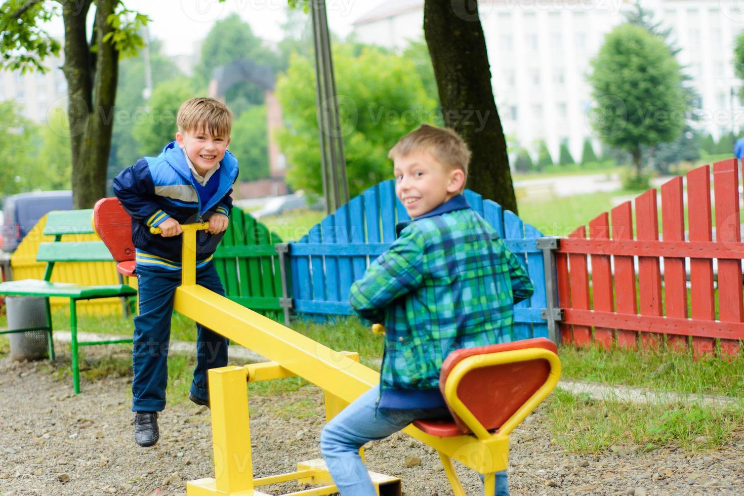 lustige Jungs schaukeln auf einem gelben Schaukelbrett foto