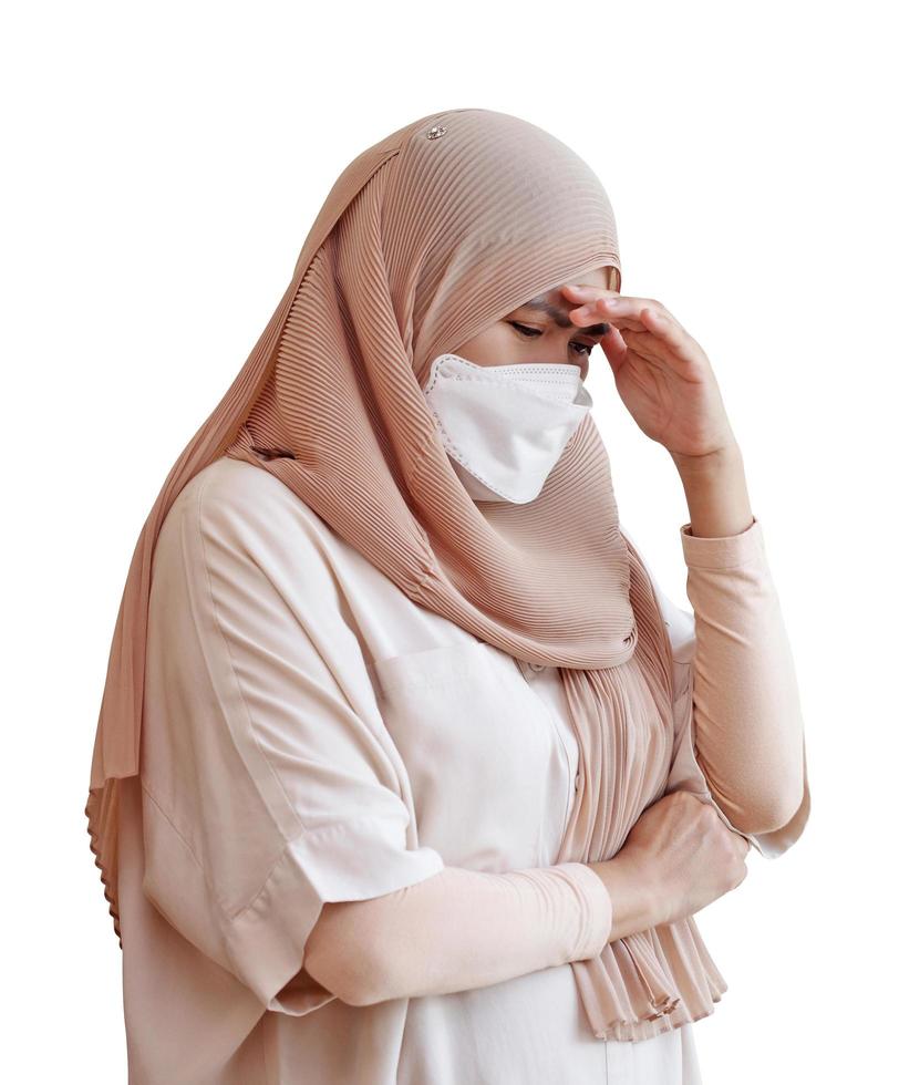 muslimische frau, die eine chirurgische maske trägt, die sich auf weißem hintergrund krank fühlt foto