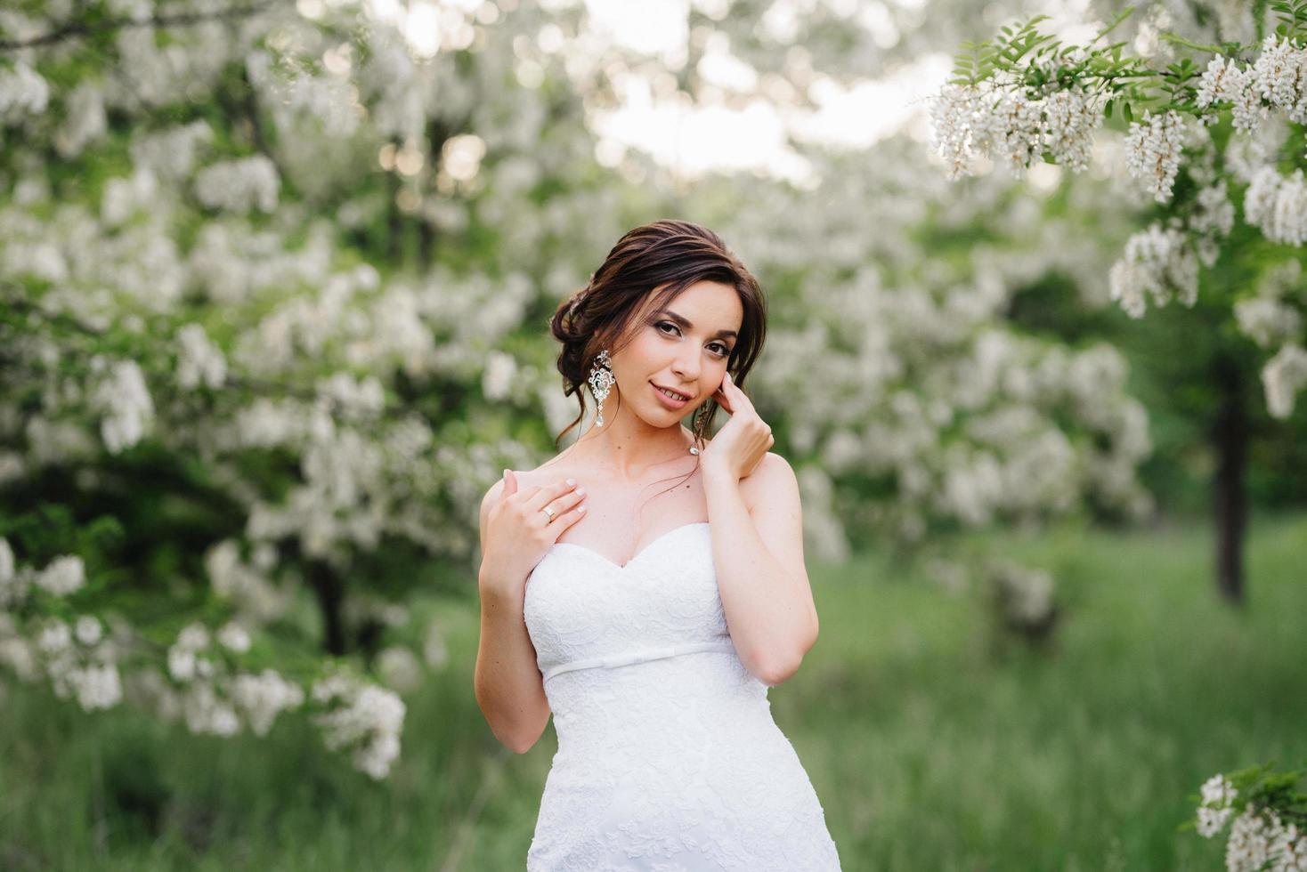 Braut im weißen Kleid mit großem Frühlingsstrauß foto