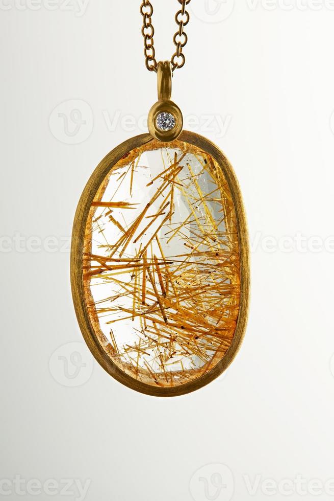 goldgelber goldanhänger mit diamant und rutilitstein auf weißem hintergrund. Schmuckherstellung foto