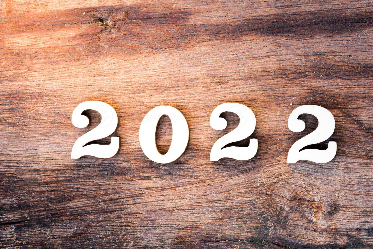 Frohes neues Jahr 2022 Konzept. Holztext auf braunem Naturholzstrukturmuster. foto