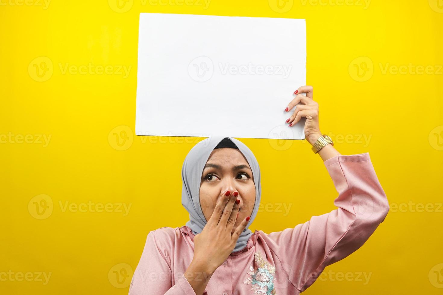 hübsche junge muslimische Frau schockiert, überrascht, wow, Hand, die leeres leeres Banner, Plakat, weiße Tafel, leeres Schild, weiße Werbetafel hält, etwas im Kopierraum präsentiert, Werbung foto