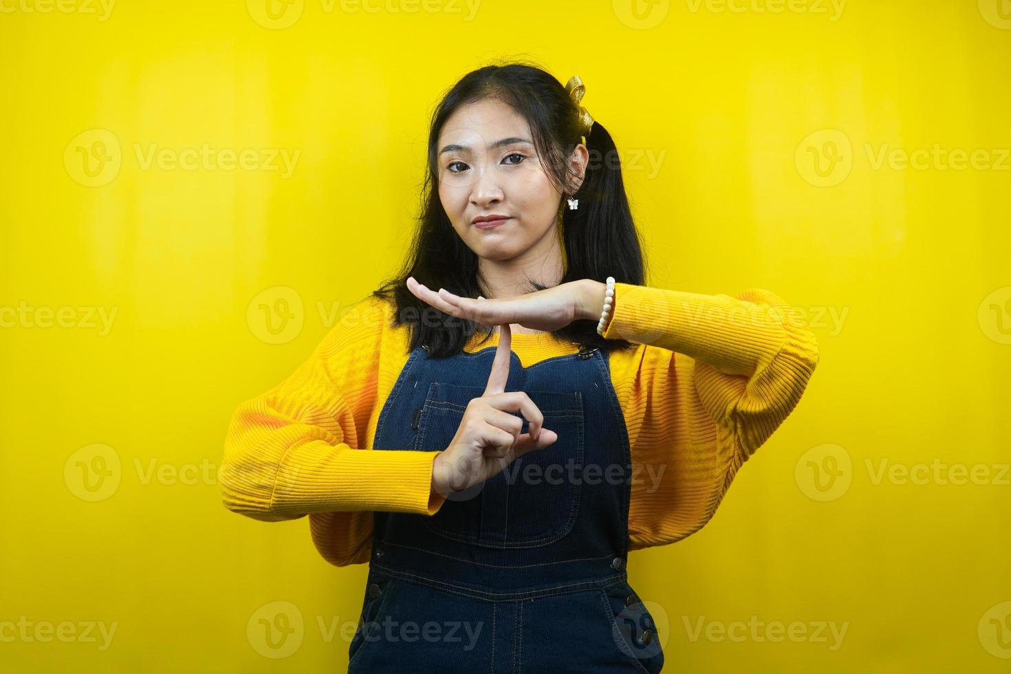 hübsche und süße junge Frau im Ernst, mit den Händen hör auf zu reden, mach keinen Lärm, bitte sei ruhig, isoliert foto