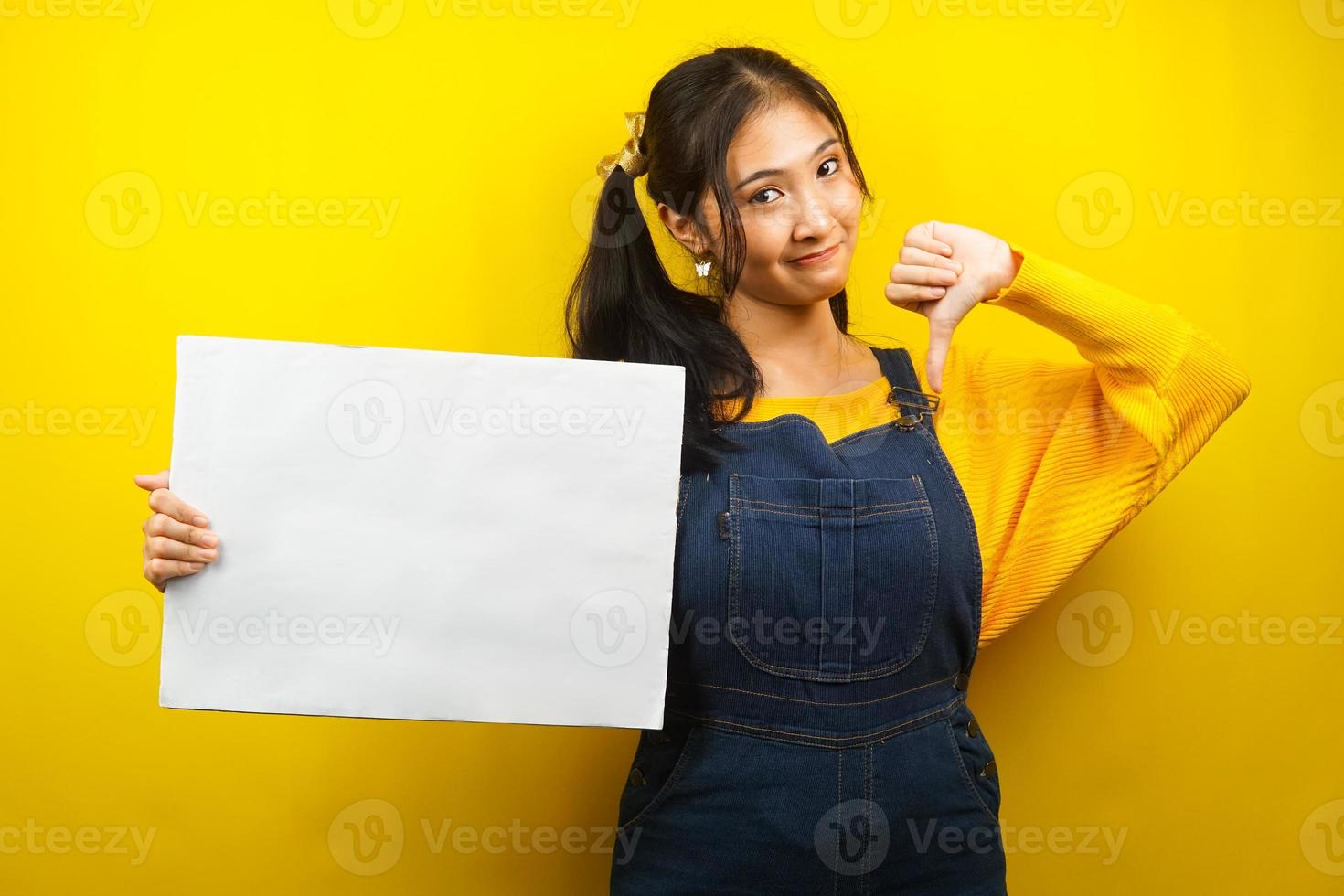 hübsche und süße junge Frau mag nicht, Hand hält leeres leeres Banner, Plakat, weiße Tafel, leeres Schild, weiße Werbetafel, präsentiert etwas im Kopierraum, Werbung foto