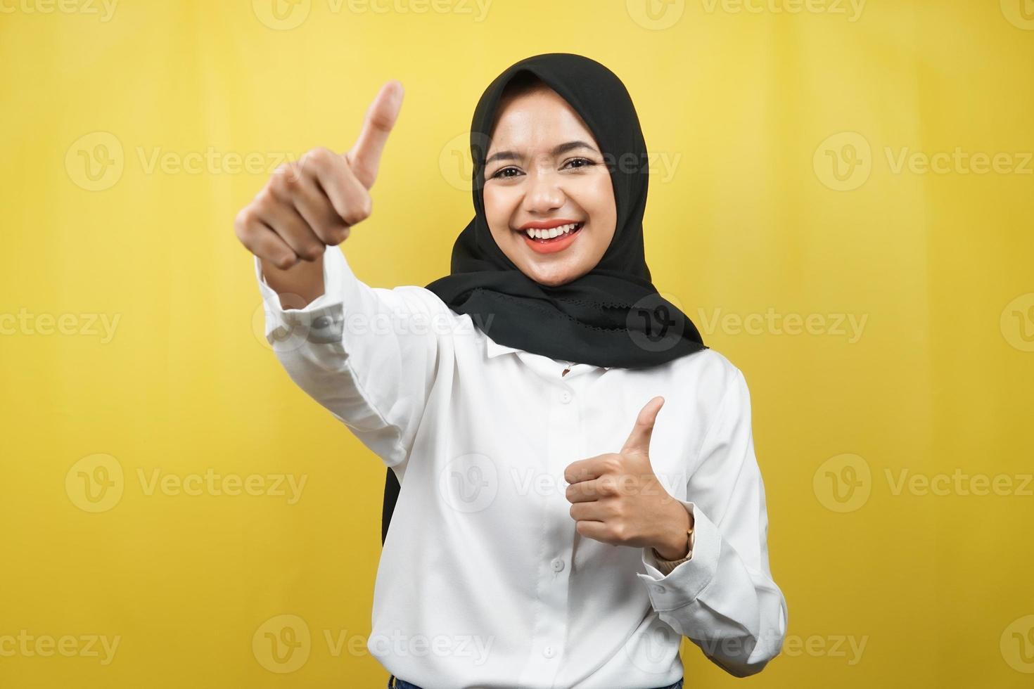 schöne junge asiatische muslimische frau, die selbstbewusst, enthusiastisch und fröhlich lächelt, mit den händen daumen hoch, ok-zeichen, erfolg, gute arbeit, erfolgszeichen, einzeln auf gelbem hintergrund foto