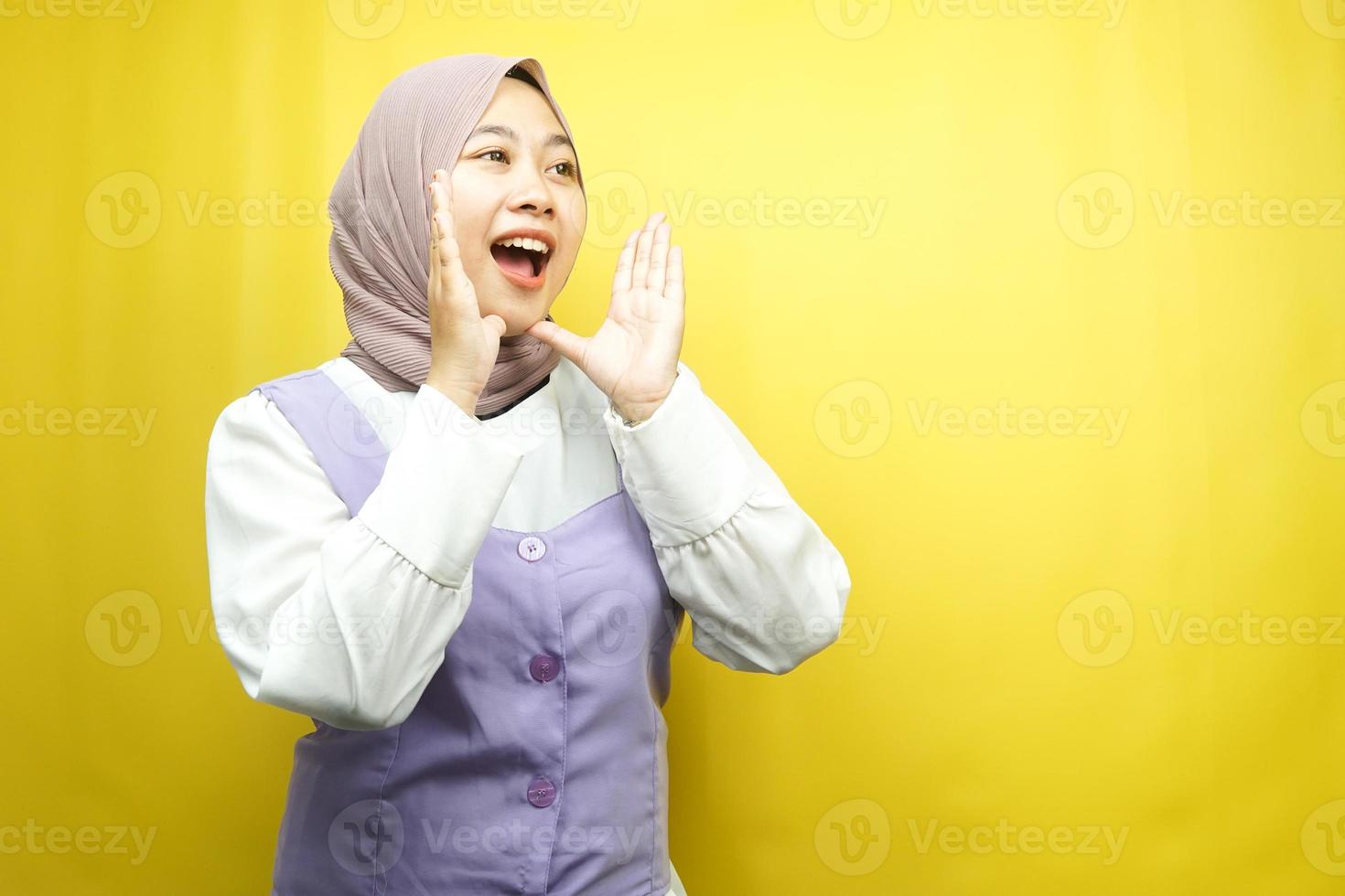 schöne junge asiatische muslimische frau schockiert, ungläubig, überrascht, einen leeren raum betrachtend, der etwas auf gelbem hintergrund isoliert präsentiert foto