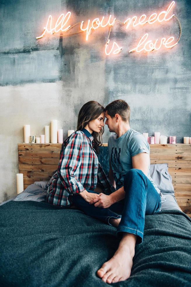 ein mann und ein mädchen sitzen auf dem bett im zimmer foto