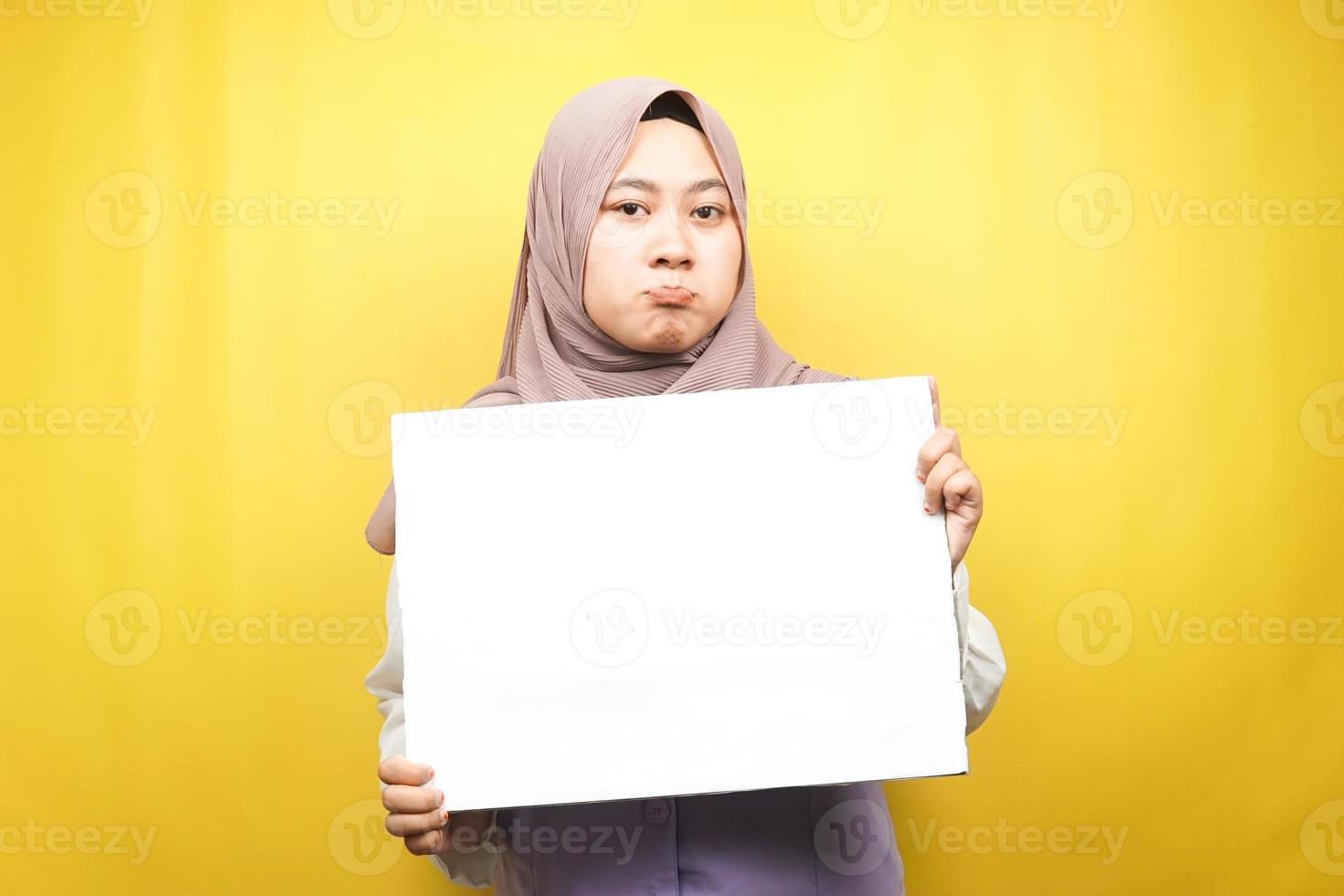 hübsche junge muslimische Frau traurig, Hand hält leeres leeres Banner, Plakat, weiße Tafel, leeres Schild, weiße Werbetafel, präsentiert etwas im Kopierraum, Werbung foto