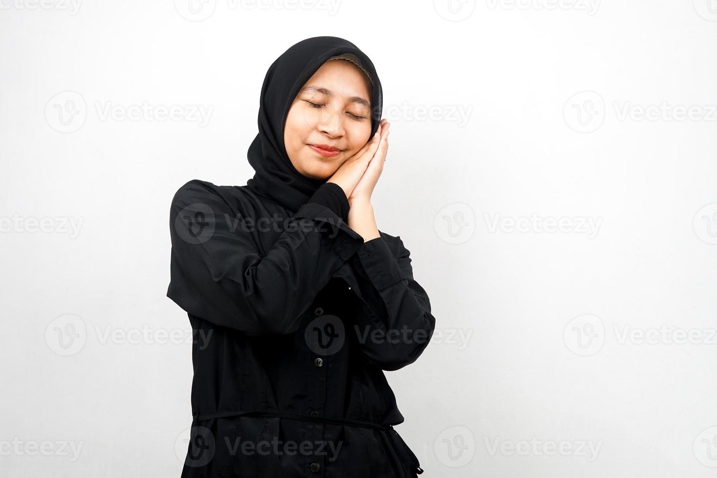 Schöne asiatische junge muslimische Frau, die friedlich schläft, sich wohl fühlt, sich glücklich fühlt, isoliert auf weißem Hintergrund foto