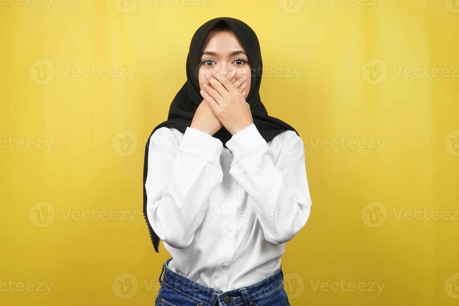 schöne junge asiatische muslimische frau schockiert, überrascht, ungläubig, bekommt schockierende informationen, mit den händen, die den mund einzeln auf gelbem hintergrund bedecken foto