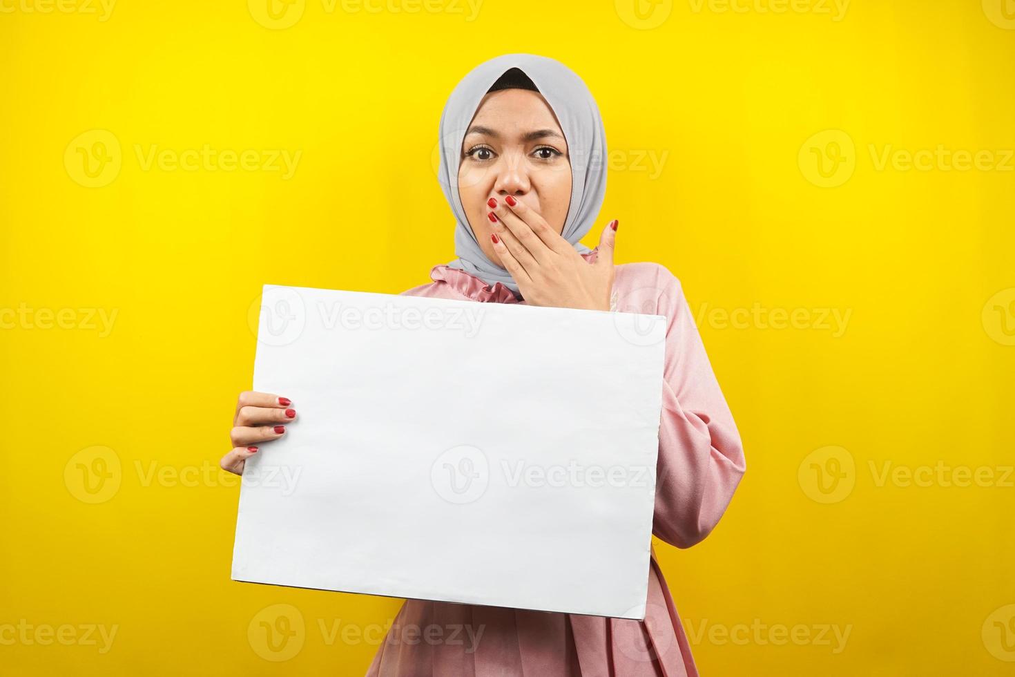 hübsche junge muslimische frau schockiert, wow, hält leeres leeres banner, plakat, weiße tafel, leeres schild, weiße werbetafel, präsentiert etwas im kopierraum, förderung foto