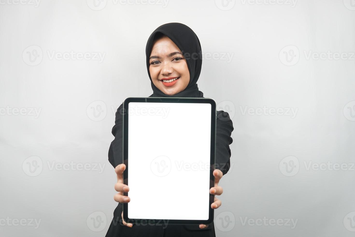 schöne junge asiatische muslimische Geschäftsfrau zuversichtlich und lächelnd, Hände halten Tablet mit weißem Bildschirm oder leerem Bildschirm, präsentieren etwas, präsentieren Produkt, präsentieren Bericht, isoliert foto