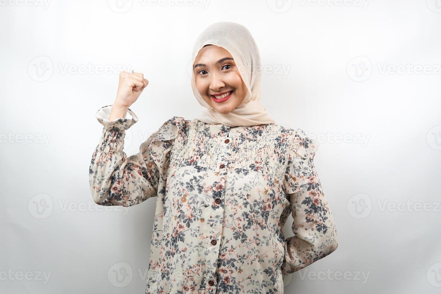 schöne asiatische junge muslimische frau mit angehobenen muskeln, kraftzeichenarme, isoliert auf weißem hintergrund foto
