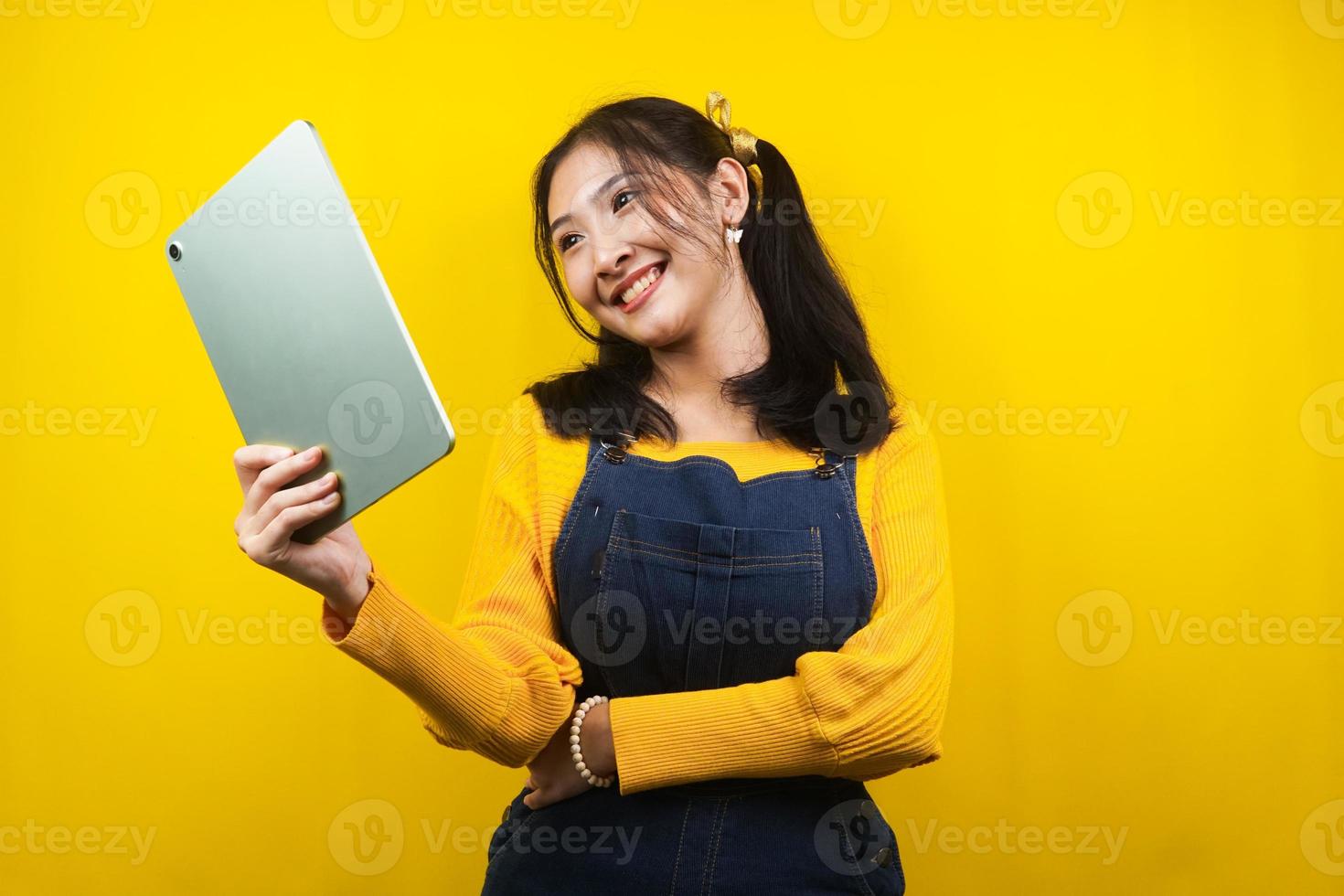 hübsche und süße junge Frau fröhlich, selbstbewusst, Hand hält Tablet, präsentiert etwas, fördert Produkt, Werbung, isoliert foto