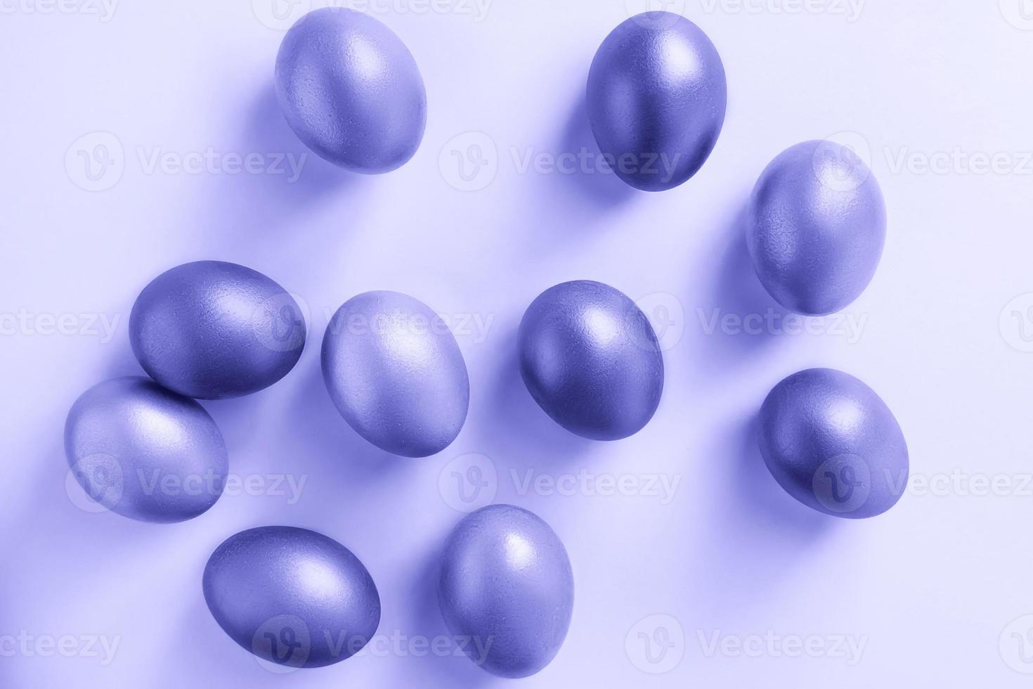 leuchtende Eier auf violettem Hintergrund. Frohe Ostern. Trendfarbe des Jahres 2022. foto