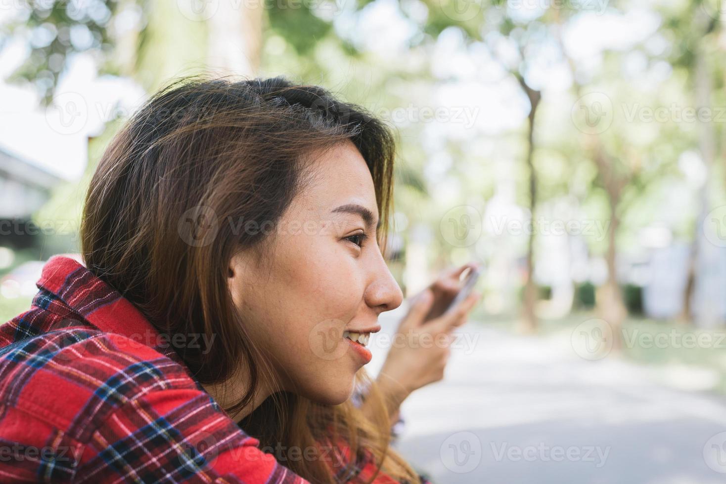 Junge asiatische Frauen sitzen und lächeln entlang der Straße und genießen ihren Lebensstil in der Stadt an einem Morgen eines Wochenendes, der auf Aktivitäten im Freien wartet. junge Frau und ihr Stadtleben. Lifestyle- und Outdoor-Konzept foto