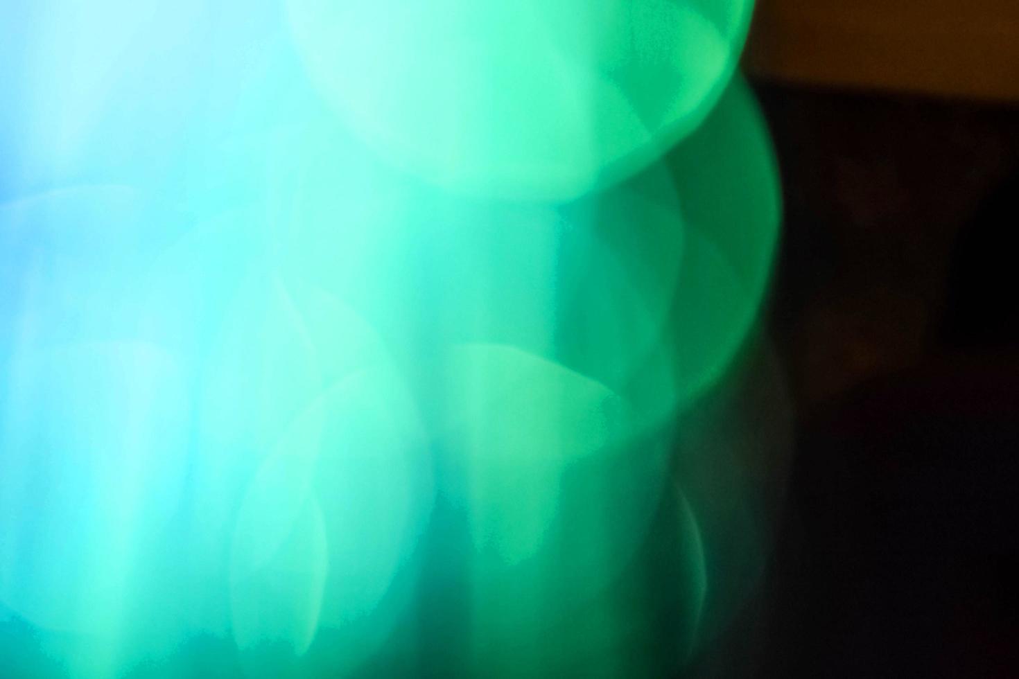 hellgrünes Neonlicht abstraktes Neon helles Lens Flare auf schwarzem Hintergrund gefärbt. dunkler abstrakter futuristischer Hintergrund und Neon foto