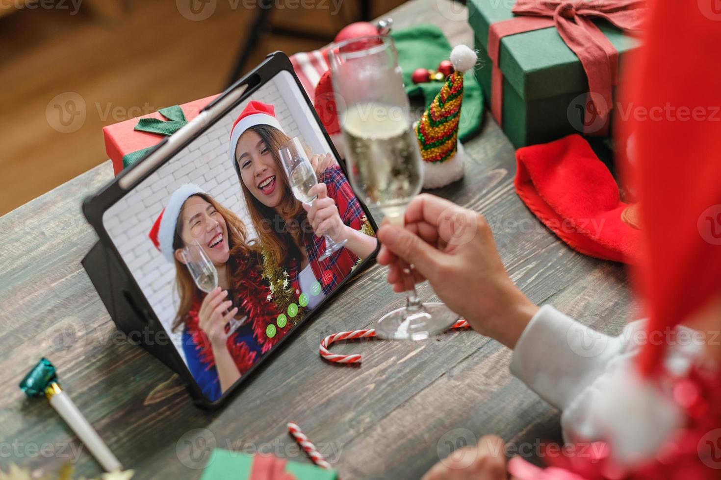 Weihnachtsfeier Videoanruf mit Freunden und gemeinsame Champagnerparty zu Hause anstoßen foto