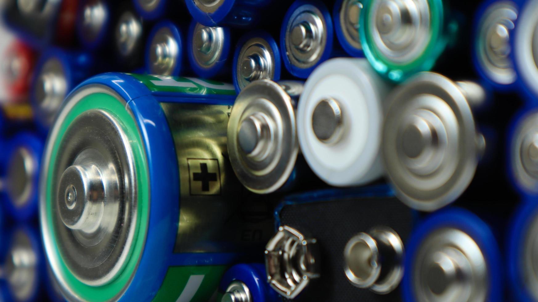 viele gebrauchte Haushalts-Alkalibatterien Typ aa, aaa, pp3, d, c, gesammelt zum Recycling. Recycling und ökologische Probleme. Draufsicht auf einen Hintergrund von gebrauchten Batterien verschiedener Typen und Größen. foto