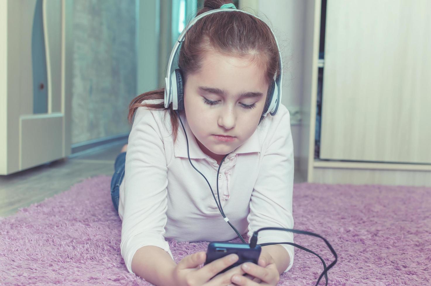 Mädchen hört Musik über Kopfhörer im Zimmer foto