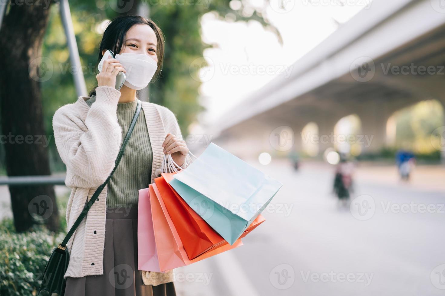 asiatische Frau, die eine Maske trägt, während sie auf der Straße geht foto