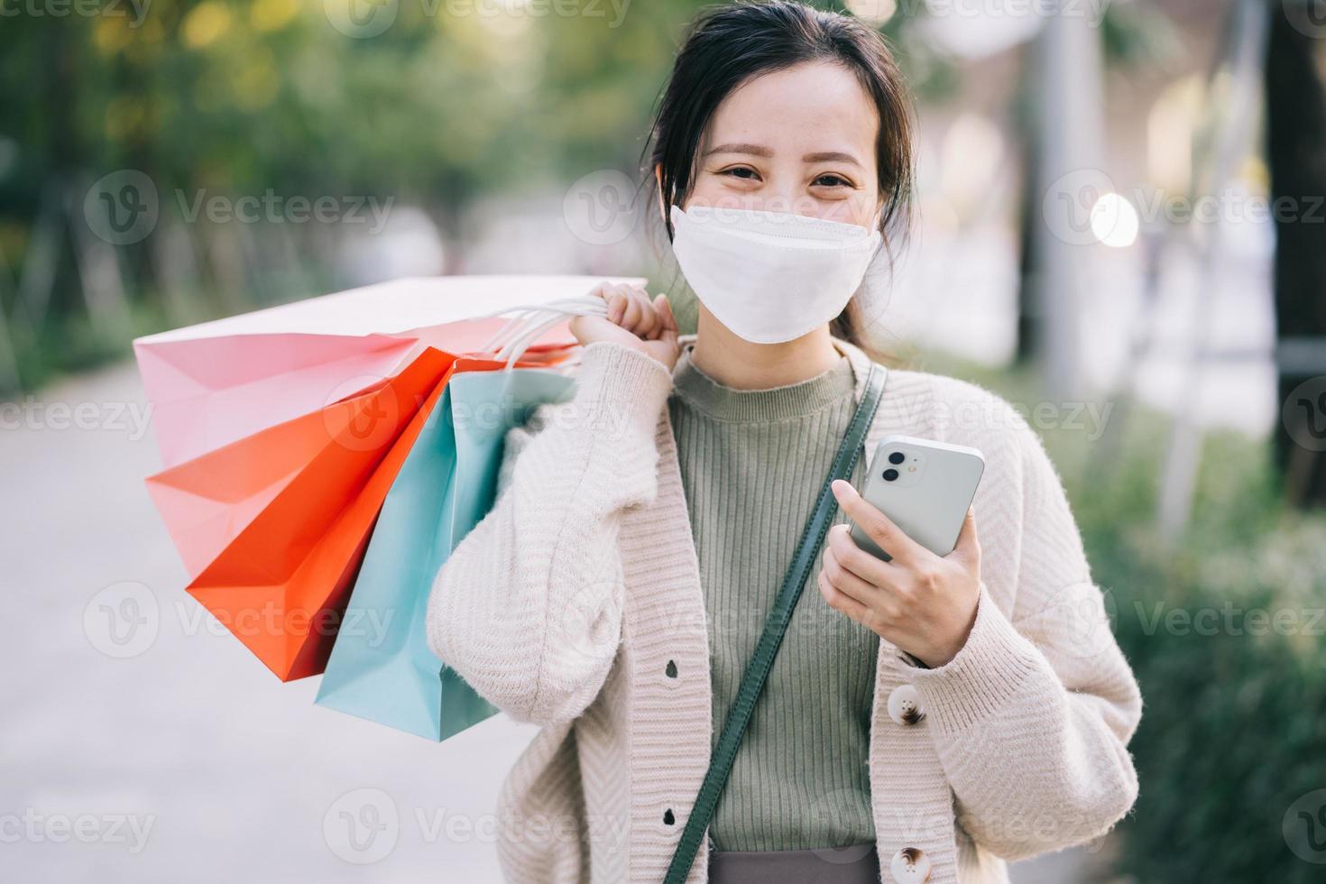 asiatische Frau, die eine Maske trägt, während sie auf der Straße geht foto