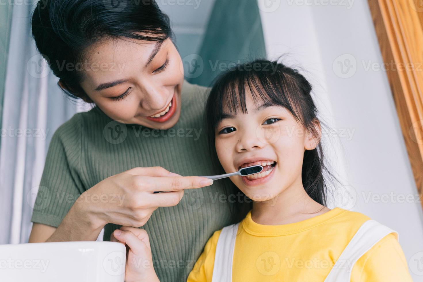 Mutter und Tochter putzen sich gemeinsam die Zähne. foto