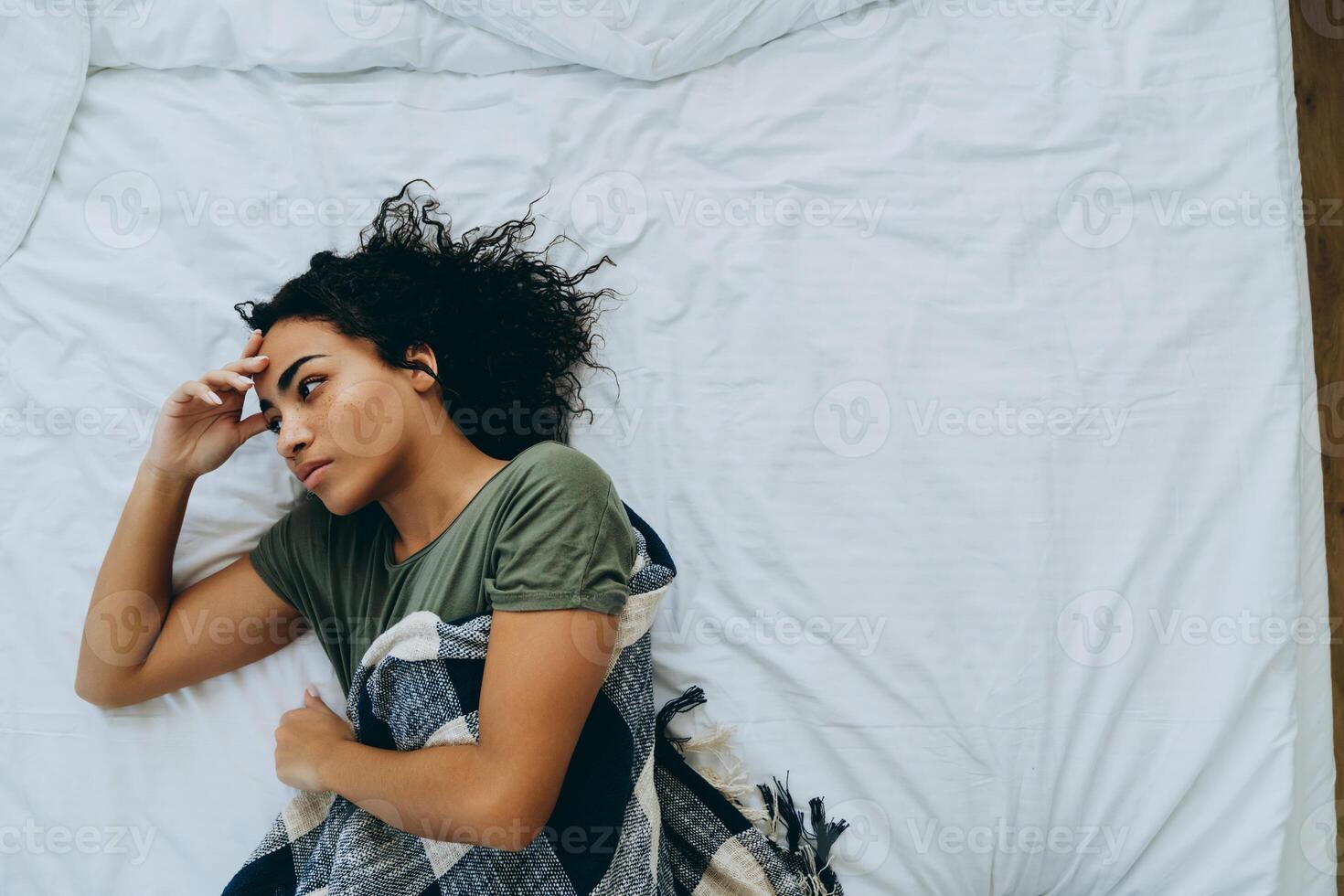 Draufsicht einer emotionslosen afrikanischen Frau, die sich in eine Decke gehüllt hat foto