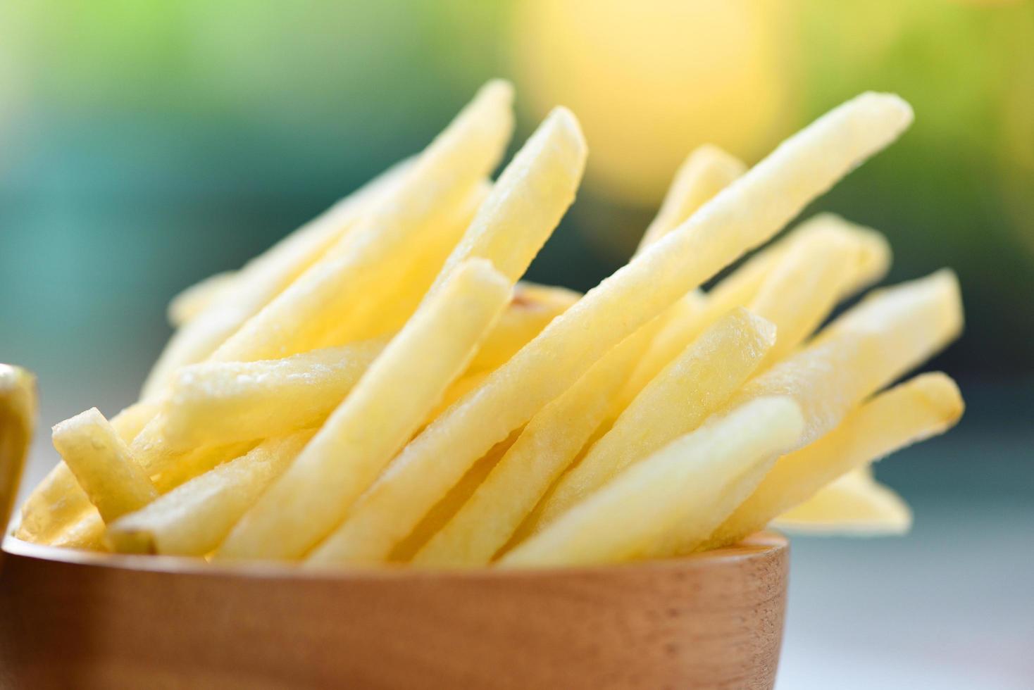 Pommes frites in Holzschale köstliche italienische hausgemachte Zutaten auf dem Tisch Natur grüner Hintergrund - leckere Kartoffel Pommes zum Essen oder Snacken foto