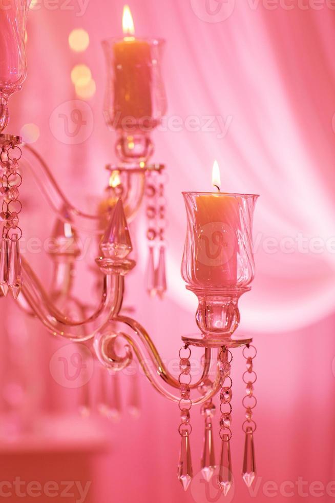Kerzen auf einem Glaskerzenständer. brennende Kerze in einem runden Glaskerzenständer mit dekorativen Muscheln foto