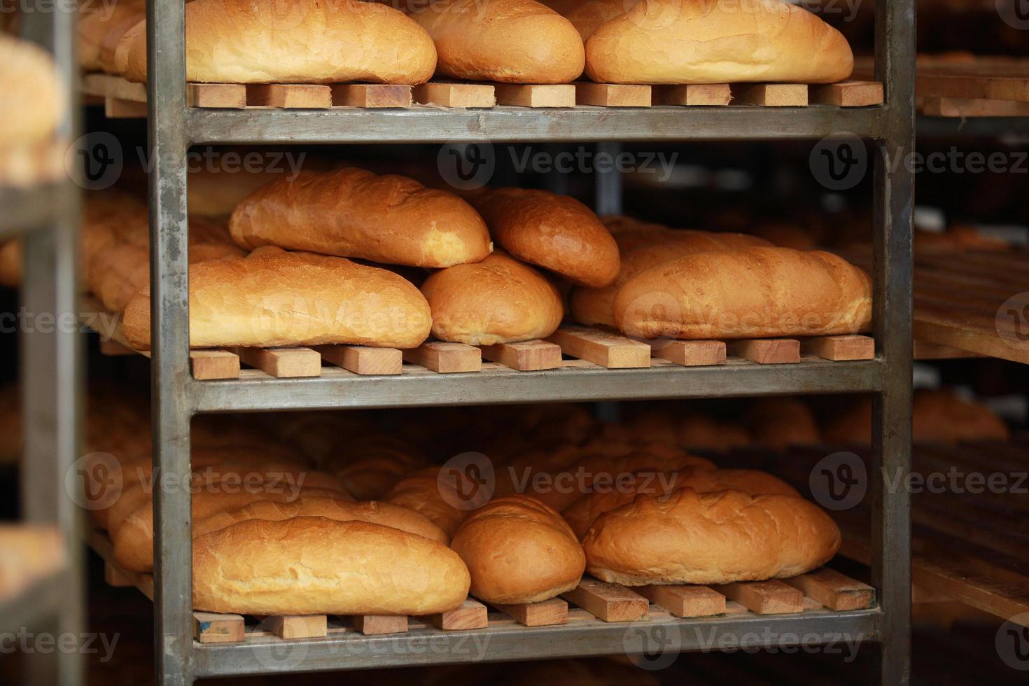 gebackenes frisches Brot im Regal. Brötchen aus dem Ofen. Brot backen. Backen transportieren. Süßwaren. foto