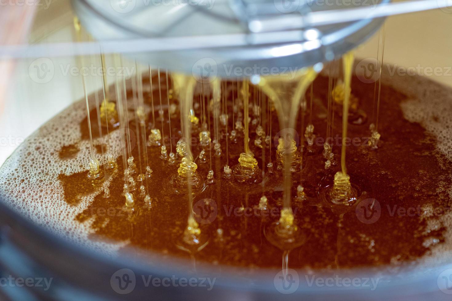 Tropfen Bienenhonig Tropfen aus sechseckigen Waben foto