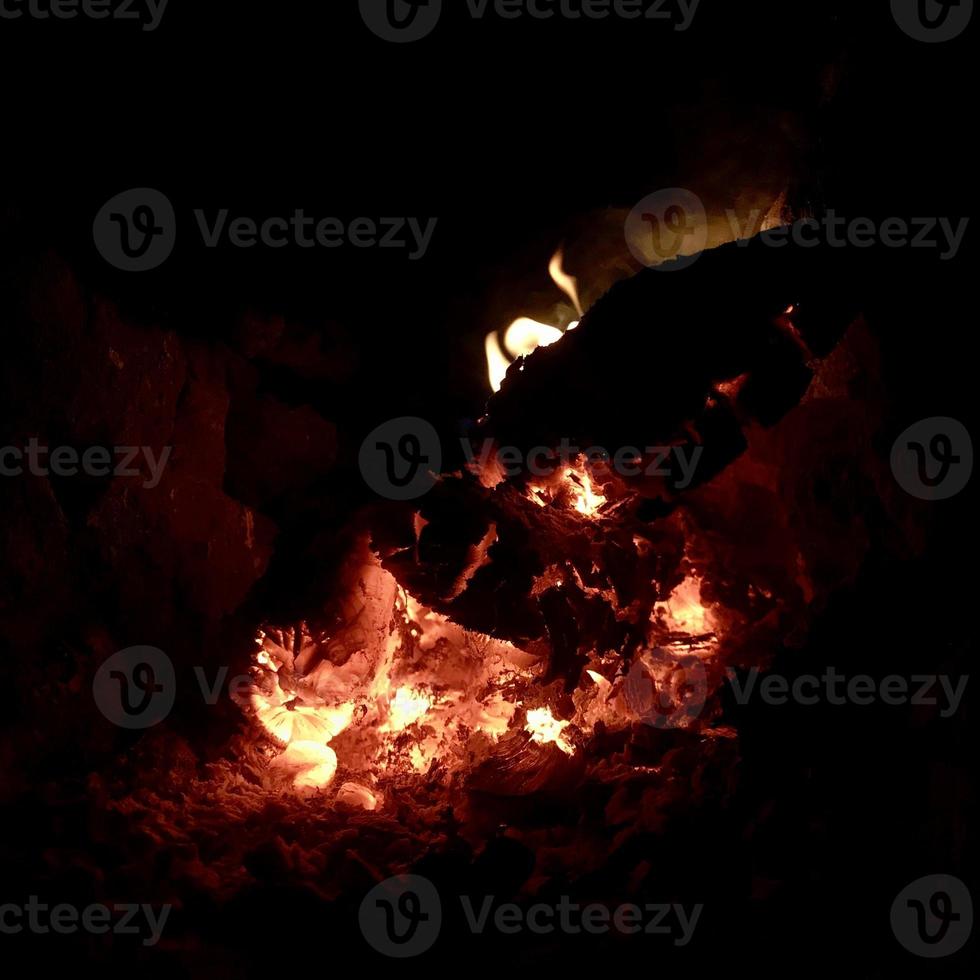 schöne flamme braunes holz dunkle schwarze kohle auf hellgelbem feuer im metallbecken foto