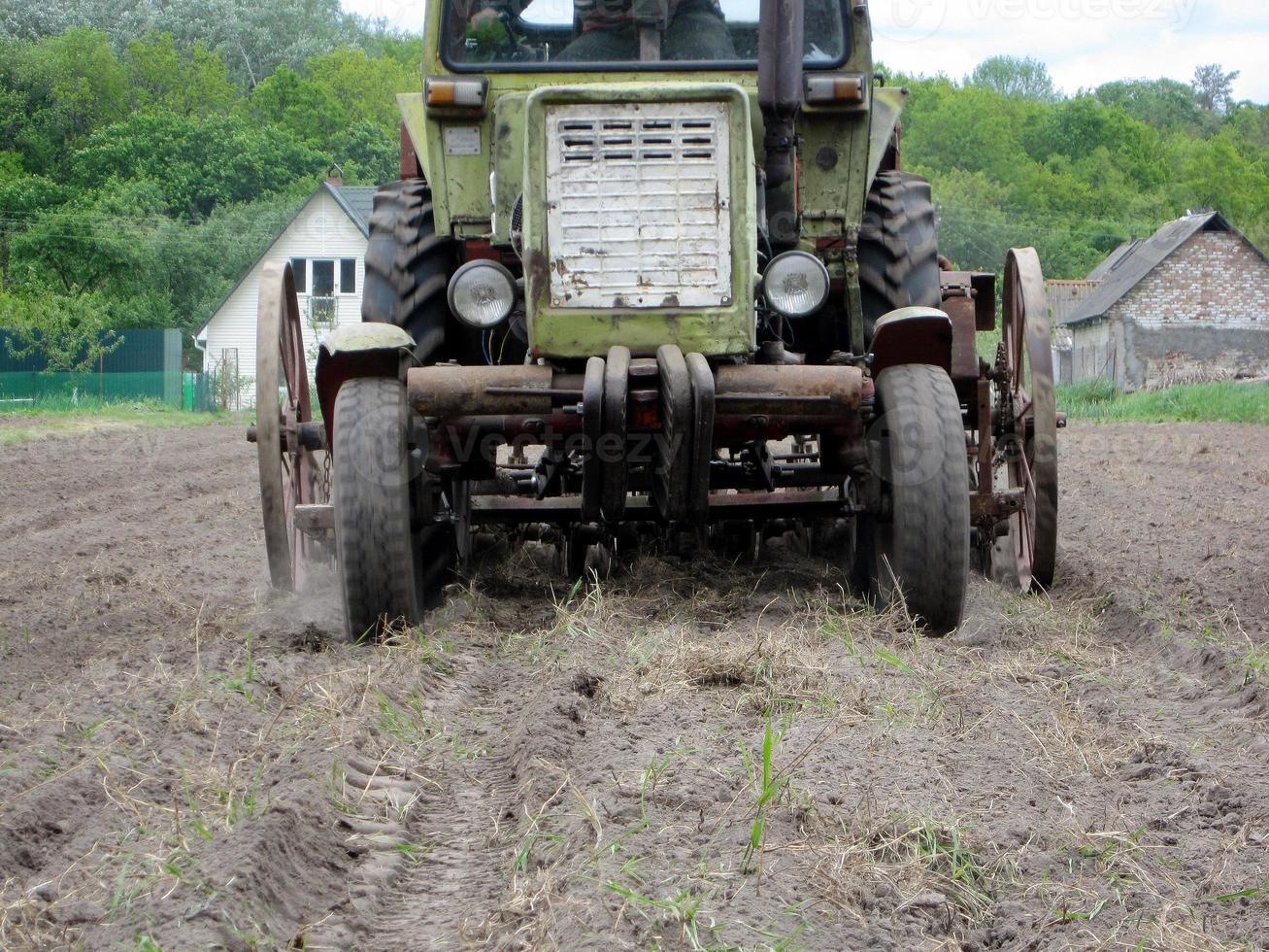 gepflügtes Feld mit Traktor in braunem Boden auf offener Landschaft Natur foto