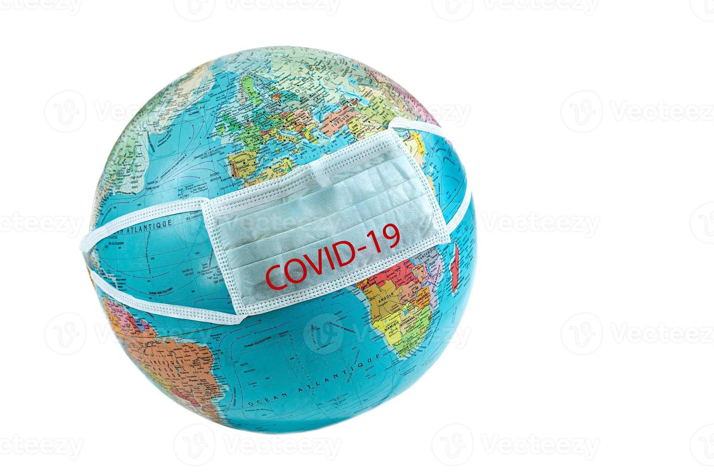 OP-Maske mit Covid- auf dem weißen Hintergrund des Planeten Erde, Ausbruch des Coronavirus foto