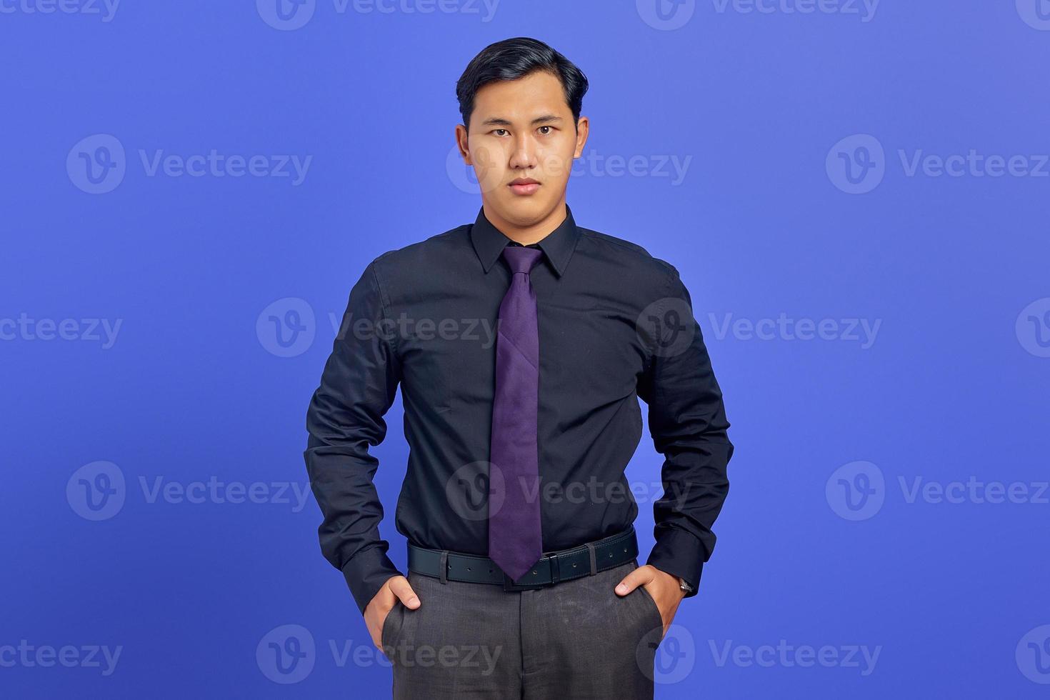lächelnder junger gutaussehender Geschäftsmann mit einem selbstbewussten Gesicht auf lila Hintergrund foto
