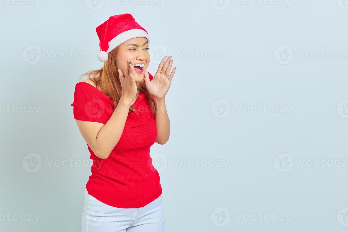 Porträt einer jungen asiatischen Frau, die ein Weihnachtskleid trägt und mit überraschtem Ausdruck schreit foto